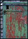 A door on an old shed. Peeling green paint reveals the older red paint. Part of Maudsley State Park in Newburyport, Massachusetts (US).