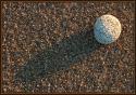 Small round rock on the coarse sand of Cape Cod, Massachusetts (US) near sunset. Camera supported by a tripod.