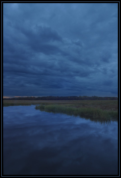 Dark, stormy clouds reflected in the water of the Newbury salt marsh (Newbury, Massachusetts US).