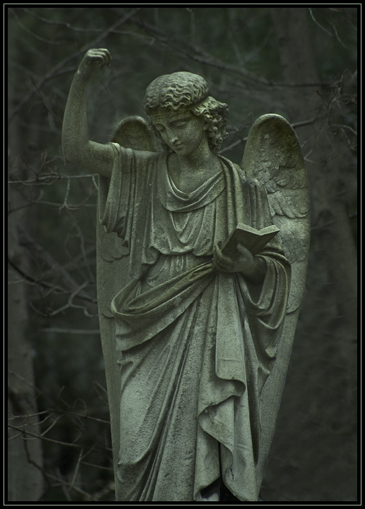 A statue of an angel on a tombstone in Pine Grove Cemetery in Lynn, Massachusetts (US). Taken in the rain on an unusually warm January evening.